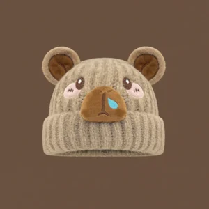 Adult knitted capybara beanie in white featuring large embroidered sparkly eyes, a cute blue nose bubble, and soft jersey lining.