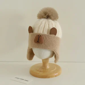 Soft Beige (Beige cuff) two-tone winter hat with a fuzzy white top, brown ribbed earflaps, and a capybara face.