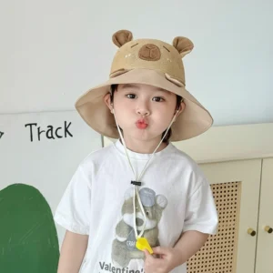 Child wearing a beige wide-brim sun hat with a breathable mesh crown, capybara face design, and a yellow safety whistle attached to the chin strap