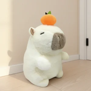 A fluffy white capybara plush toy sitting upright with closed eyes and a bright orange fruit balanced on its head, measuring 23cm tall.