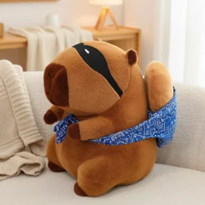 A brown capybara plush toy wearing a black bandit eye mask and carrying a blue bandana sack on its back, sitting on a couch.