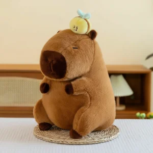 Chubby brown capybara plush sitting with closed eyes, featuring a yellow retractable bee toy attached to the top of its head.