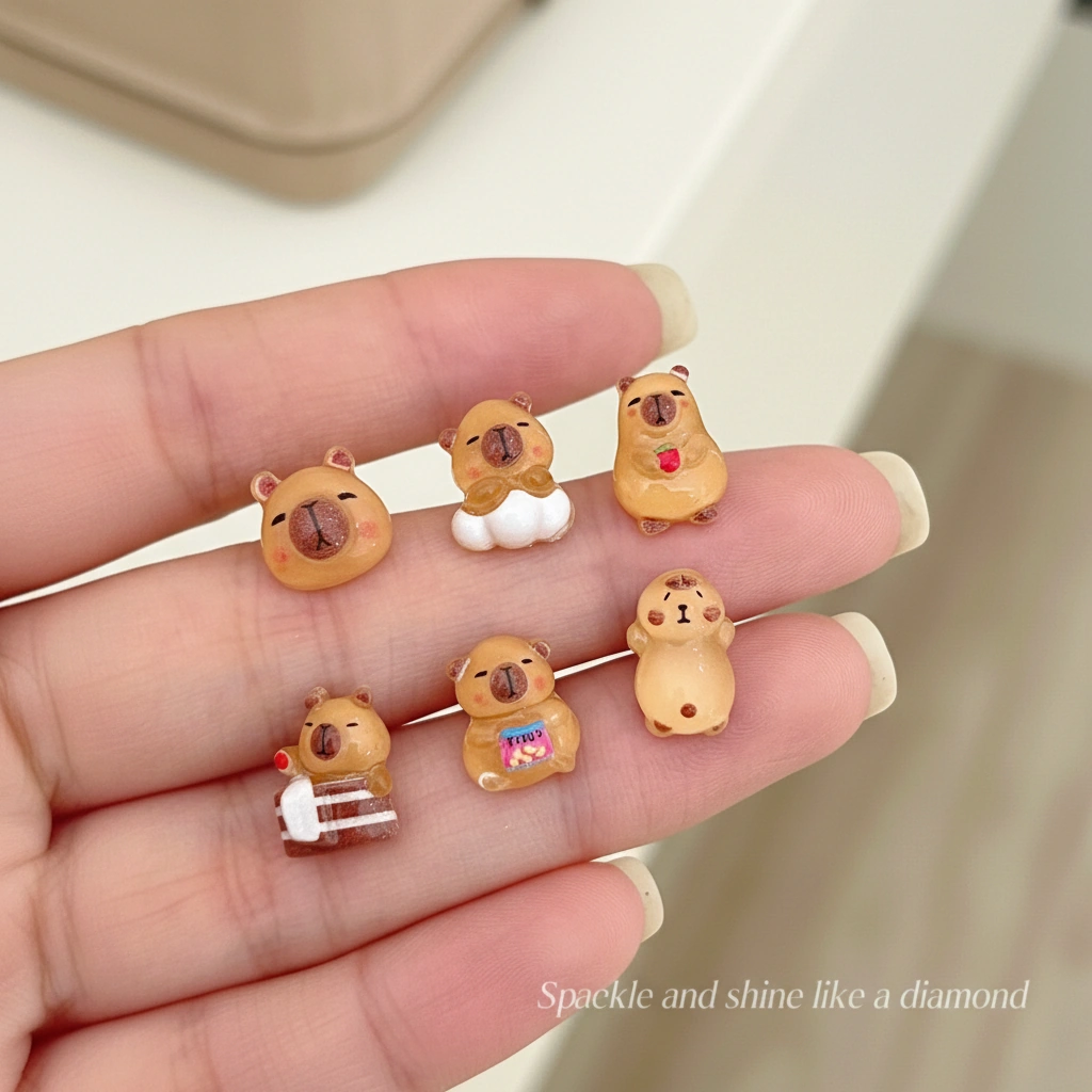 A collection of six pairs of mini capybara stud earrings featuring a capybara sleeping, wearing pajamas, bathing, and eating snacks.