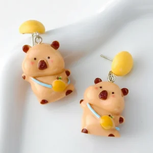 Large vibrant dopamine orange capybara dangle earrings featuring a 3D capybara with a giant orange, available in silver needles and clip-on styles.