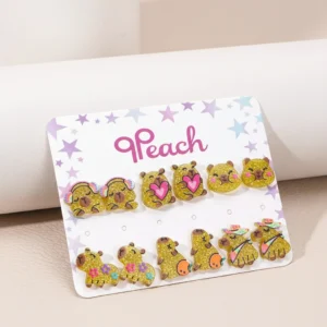 A set of six pairs of colorful capybara stud earrings featuring various themes like fruit hats, dinosaur costumes, and boba tea.