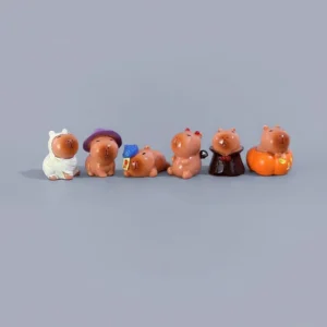 A 6-piece set of miniature capybara figures dressed in Halloween costumes including pumpkins, witch hats, and ghost hats.