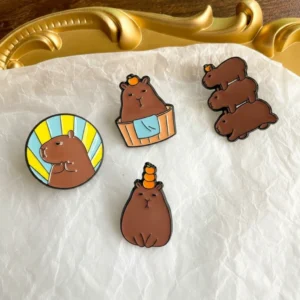 Set of four dark brown enamel pins showing a holy meditating capybara, one bathing in a tub, one balancing oranges, and a stack of three capybaras.
