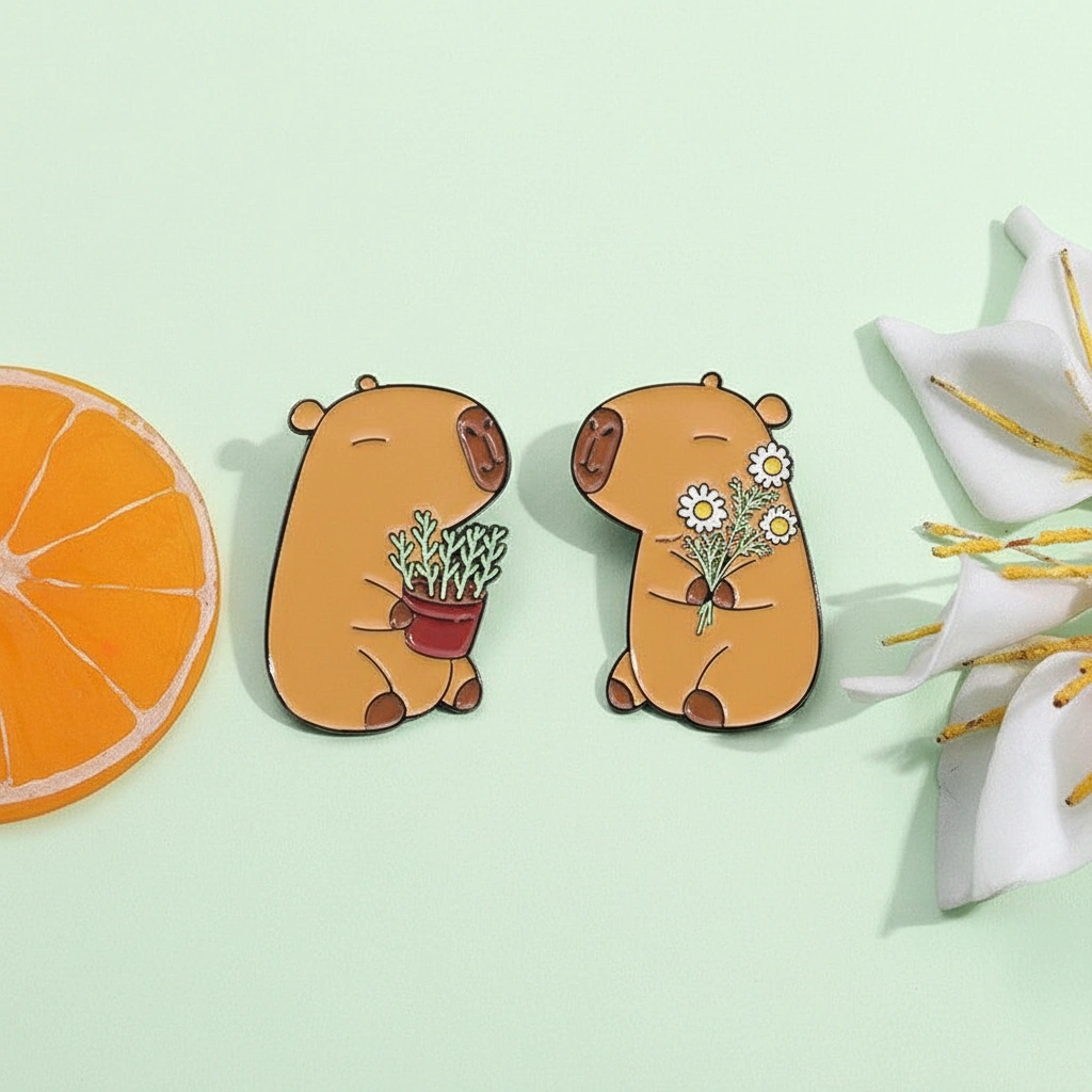 Two cute enamel pins featuring a capybara holding a potted plant and another holding a bunch of white daisy flowers.