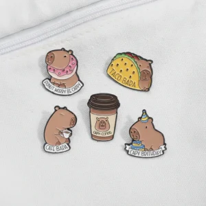 Set of five food-themed enamel pins featuring a capybara taco, donut, coffee cup, drinking coffee, and holding a birthday cake with funny text puns.