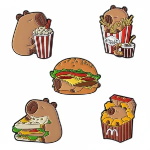 Set of five food-themed enamel pins featuring a capybara taco, pink donut, coffee cup, cafe saucer, and birthday cake with funny text.