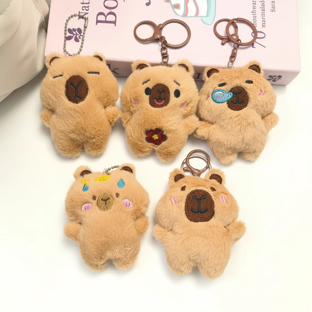 A collection of five 9cm brown capybara plush keychains showing different emotions, including sleeping, holding a flower, and having a snot bubble.