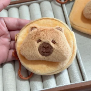 Soft yellow plush capybara wallet coin purse shown in and round shapes, featuring a 3D brown snout and hanging clip.